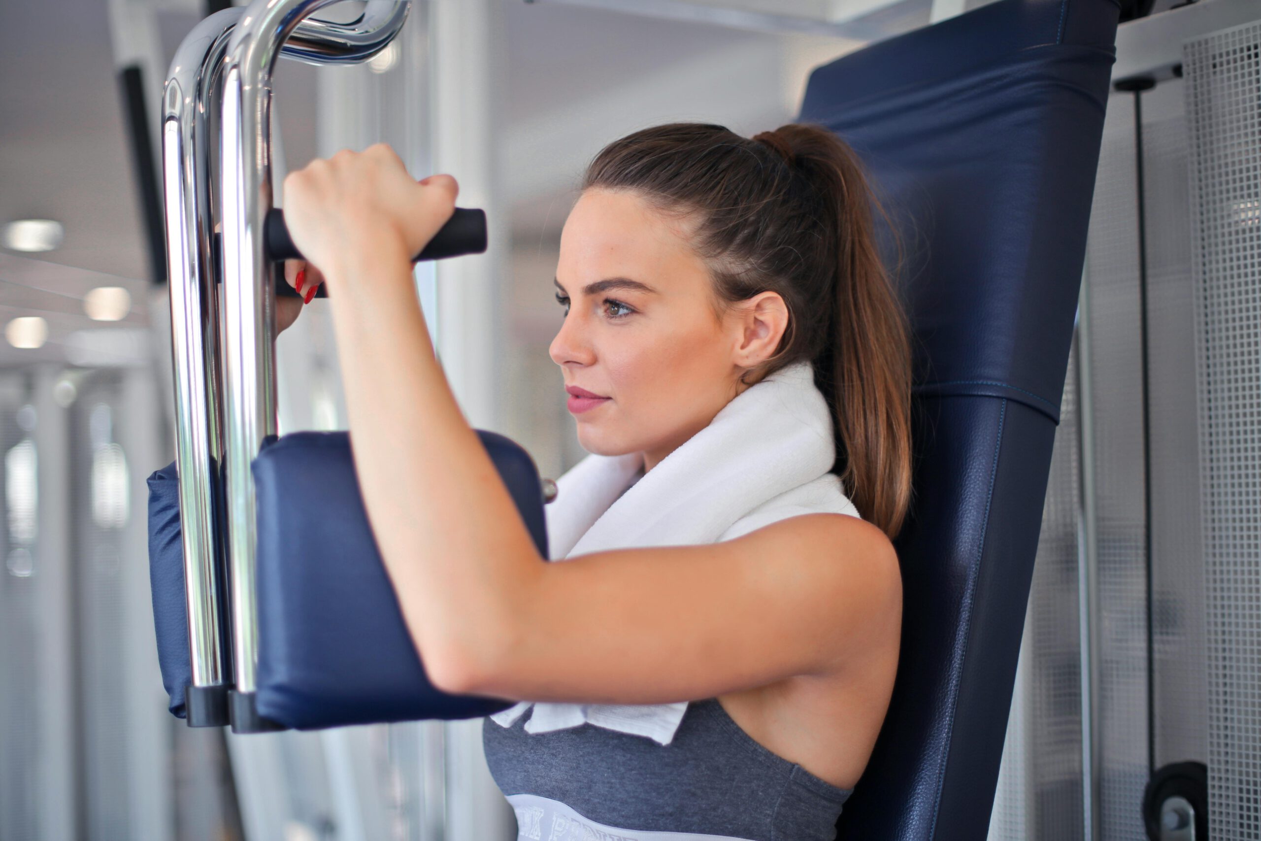 Junge Entschlossene Sportlerin, Die übung Auf Kraftmaschine Im Modernen Sportverein Tut